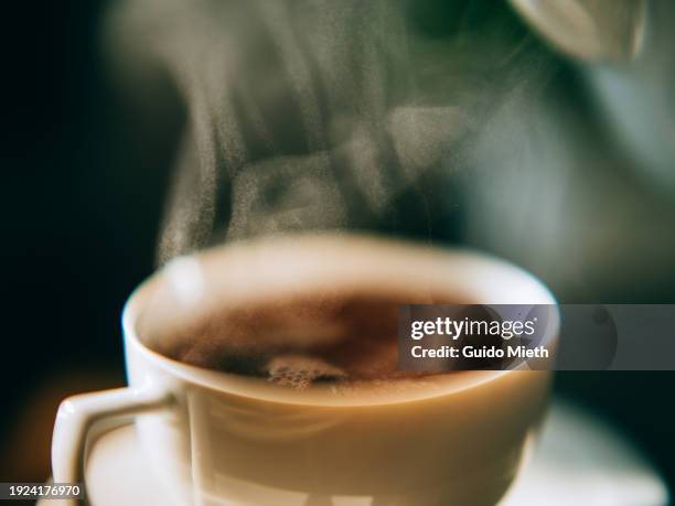 cup of steaming tea in front of laptop on a wooden table. - broken mug stock pictures, royalty-free photos & images