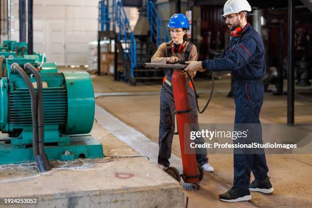 young workers stay cool under pressure - fire extinguisher inspection stock pictures, royalty-free photos & images