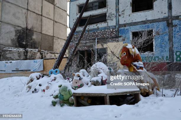 Spontaneous memorial with children's toys covered with snow dedicated to the victims of the Russian rocket attack seen by the apartment building that...
