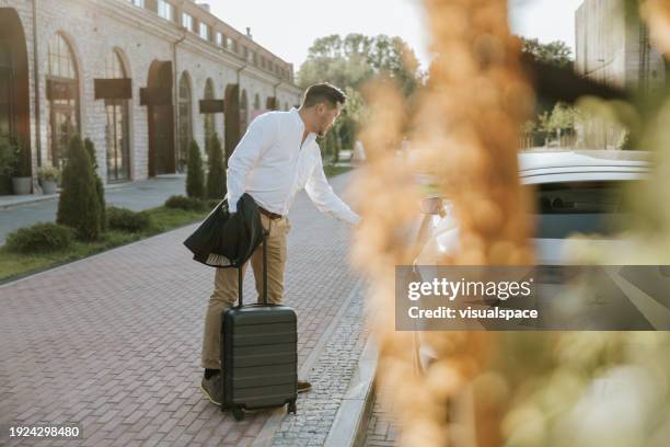 japanese businessman taking a ridesharing car in business district - taxi stock pictures, royalty-free photos & images