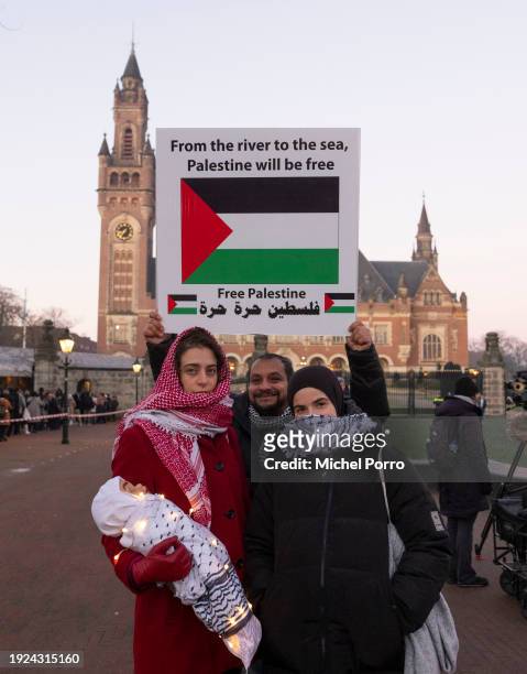 Protesters stand outside the International Court of Justice in support of the Palestinian people as South Africa has requested the court to indicate...