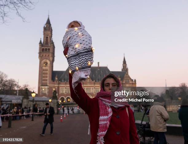 Protester holds up a baby doll and stands outside the International Court of Justice in support of the Palestinian people as South Africa has...