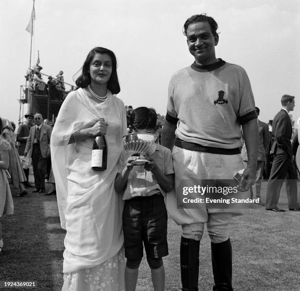 Sawai Man Singh II , the Mahrajah of Jaipur, and his wife, Maharini Gayatri Devi , with their son Prince Jagat Singh holding a trophy at a polo...