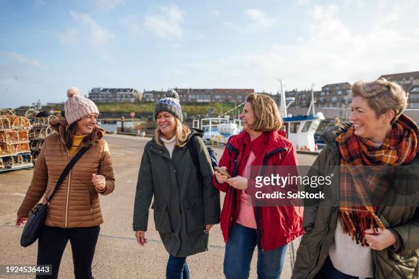 a walk on the harbour - women stock pictures, royalty-free photos & images