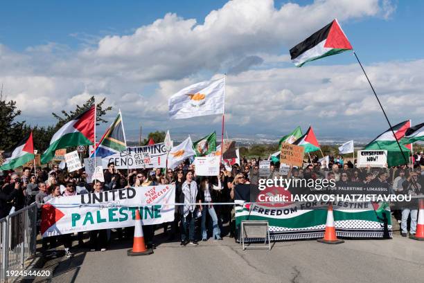 Peace protesters wave Palestinian flags in front of the gates of the Royal Air Force Akrotiri base, a British overseas territory near the Cypriot...