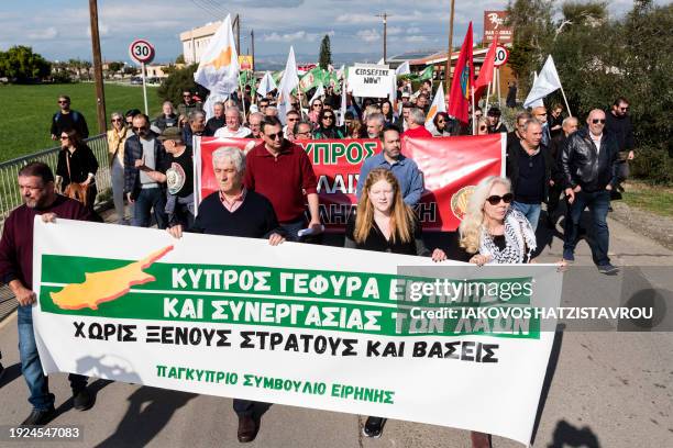 Peace protesters raise placards in front of the gates of the Royal Air Force Akrotiri base, a British overseas territory near the Cypriot coastal...