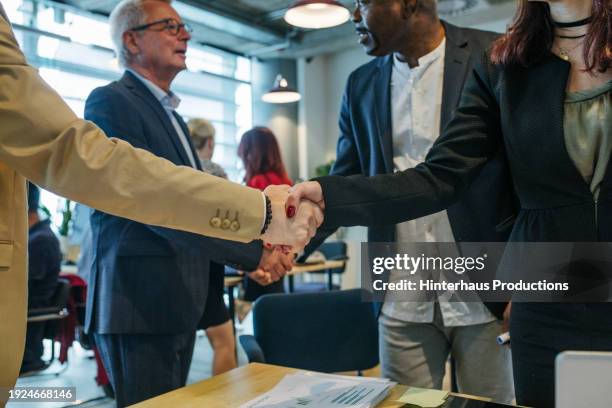 close-up of business associates shaking hands - business hand shake with arabs stock pictures, royalty-free photos & images