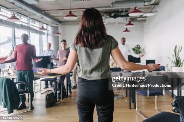 woman leading group in meditation at office - yoga office arab stock pictures, royalty-free photos & images