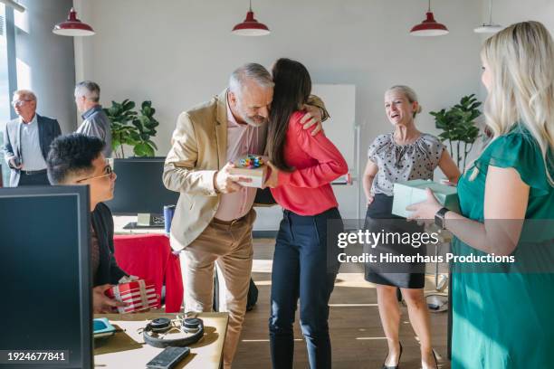 businessman embracing colleague during birthday party at office - feier am arbeitsplatz stock-fotos und bilder