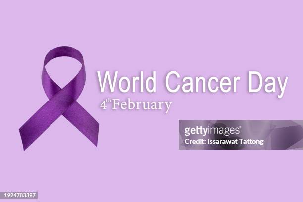 purple ribbon on pastel paper background for supporting world cancer day campaign on february 4. - dia mundial do cancro imagens e fotografias de stock