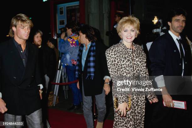 American actress Patti D'Arbanville, wearing a leopard-print dress, and a guest, who wears a black suit with a white shirt and black tie, attend the...