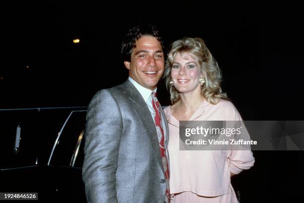 American actor Tony Danza, wearing a grey mohair suit over a white shirt with a red-and-white patterned tie, and his wife, Tracy, who wears a pale...