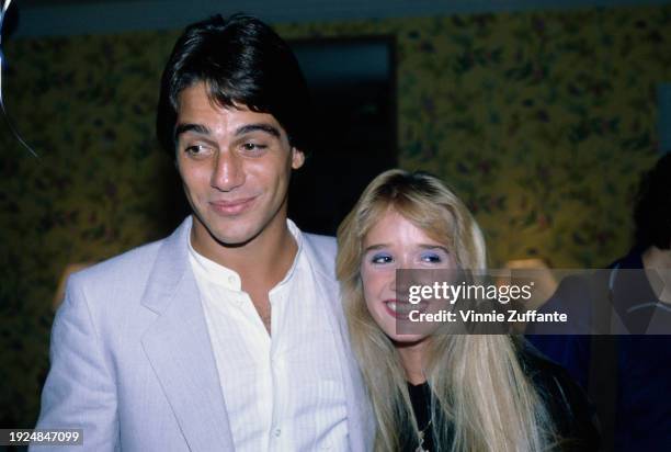 American actor Tony Danza, wearing a light grey suit over a white shirt, open at the collar, and his wife, Tracy, United States, circa 1990.