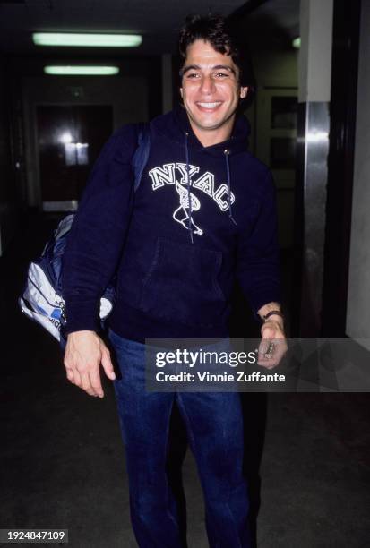 American actor Tony Danza wearing a dark blue New York Athletic Club hooded sweatshirt, with an adidas shoulder bag over his right shoulder, United...