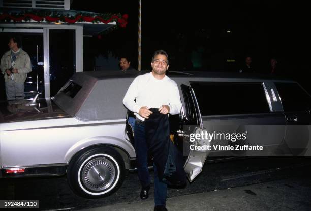 American actor Tony Danza, wearing a long-sleeve white t-shirt, and carrying a black jacket, emerges from his car to attend the premiere of 'Hook',...