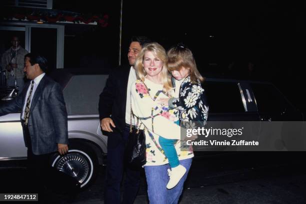 American actor Tony Danza, wearing a black jacket over a white t-shirt, and his wife, Tracy, who wears a white floral-pattern sweater and carries...