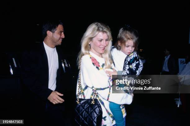 American actor Tony Danza, wearing a black jacket over a white t-shirt, and his wife, Tracy, who wears a white floral-pattern sweater and carries...
