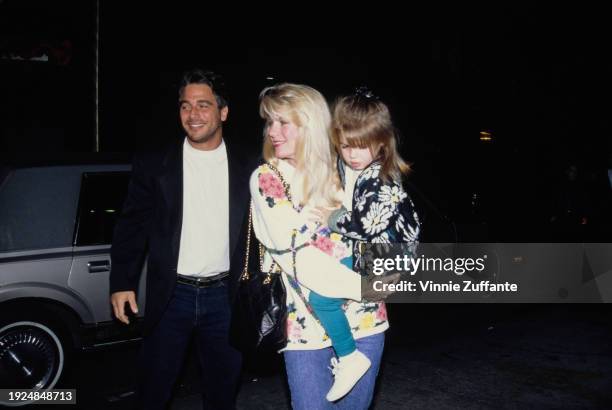 American actor Tony Danza, wearing a black jacket over a white t-shirt, and his wife, Tracy, who wears a white floral-pattern sweater and carries...