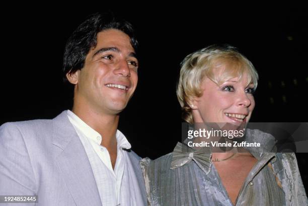 American actor Tony Danza, wearing a light grey suit over a white shirt which is open at the collar, and German actress Elke Sommer, who wears a grey...