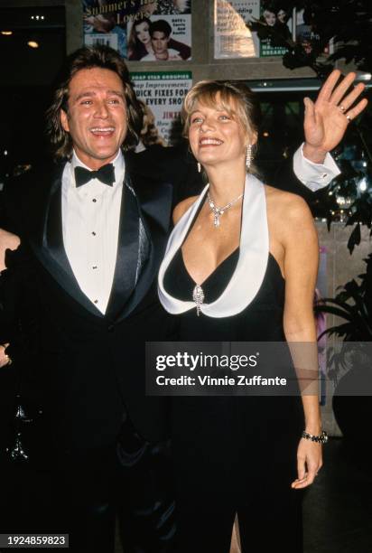 American actor Frank Dicopoulos, wearing a tuxedo and bow tie, and his wife, Teja Anderson, who is wearing a black-and-white outfit, attend the 10th...