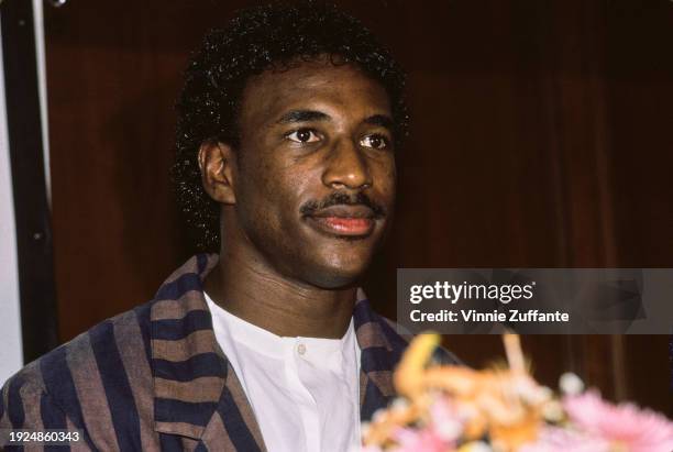 American football player Eric Dickerson, wearing a striped blazer over a white collarless shirt, attends the press conference ahead of 'The Concert...