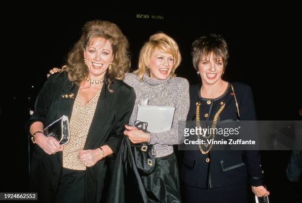 British author Jackie Collins, wearing a black jacket over a leopard-print v-neck top, American actress Angie Dickinson, who wears a grey turtleneck...