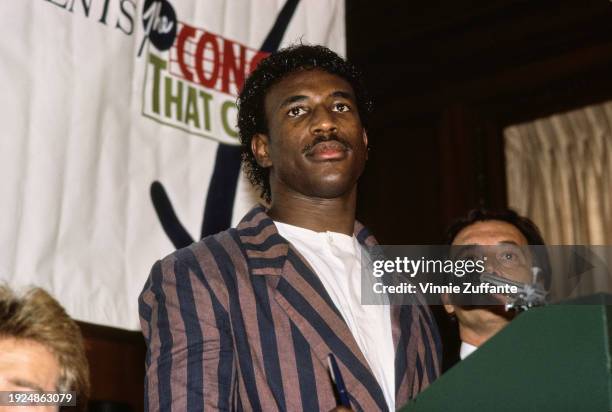 American football player Eric Dickerson, wearing a striped blazer over a white collarless shirt, attends the press conference ahead of 'The Concert...