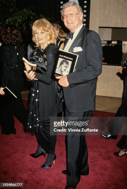 American actress Angie Dickinson, wearing a black outfit, and American actor and comedian Charles Nelson Reilly, who wears a tuxedo and bow tie,...