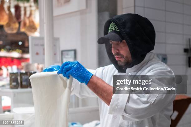Chef stretching fresh mozzarella cheese in the kitchen at Eataly, Westfield Mall, San Jose, California, December 2, 2023.