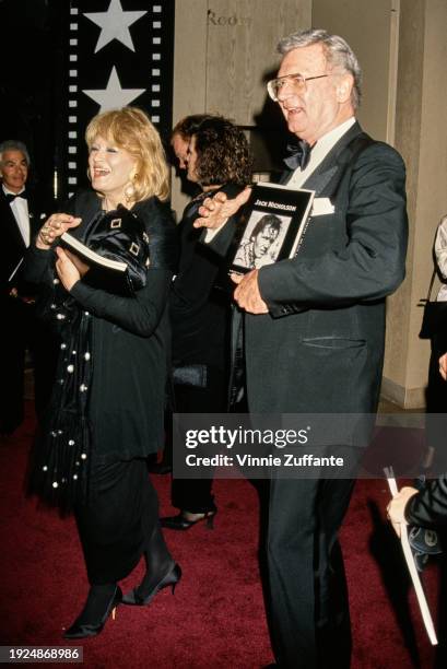 American actress Angie Dickinson, wearing a black outfit, and American actor and comedian Charles Nelson Reilly, who wears a tuxedo and bow tie,...