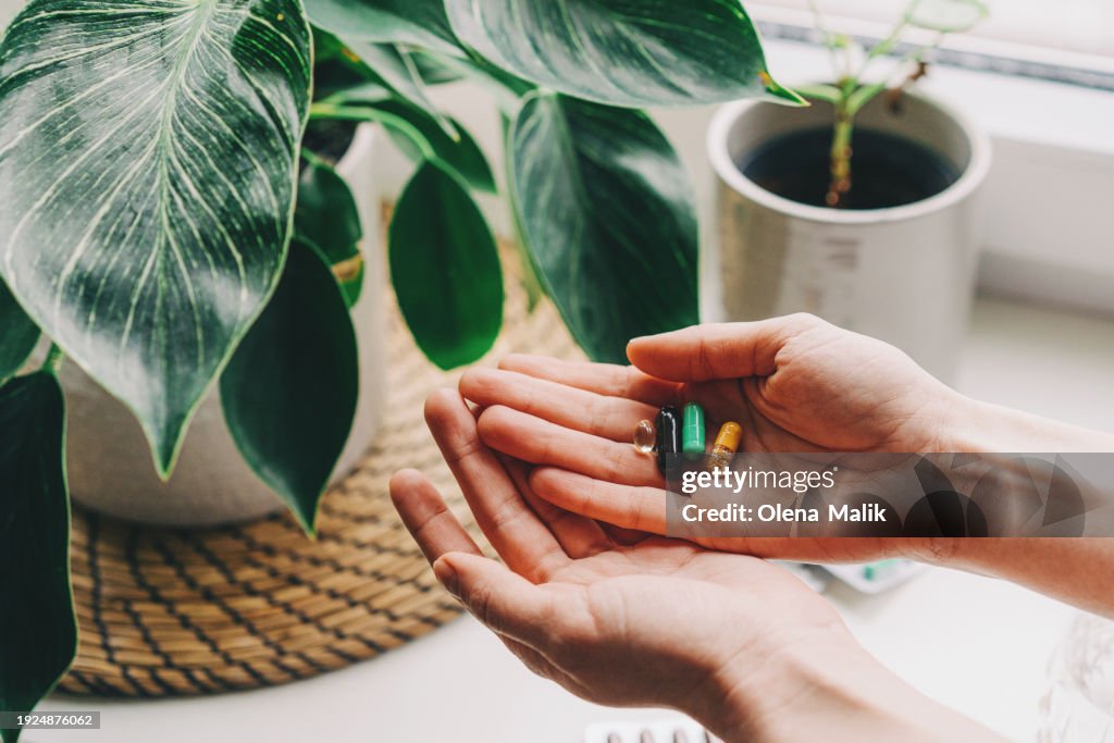 Woman taking vitamins and supplements. Medical concept.