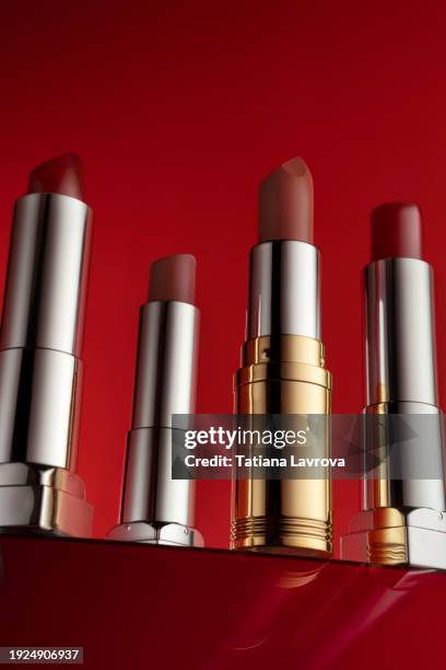 set of lipsticks on rich red background. luxury commercial photography with copy space. close up, hero shot view. mockup template with space for your logo, text, design elements - 赤の口紅 ストックフォトと画像