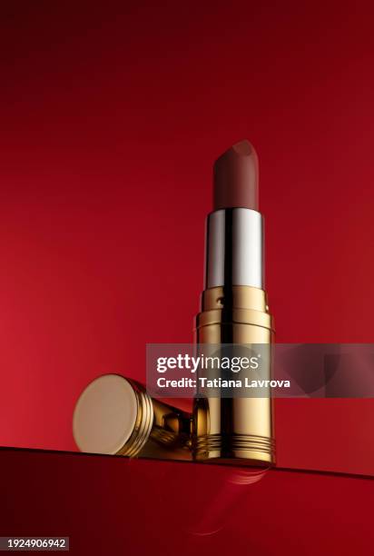 lipstick tube with glossy cap on rich red background. luxury commercial photography with copy space. close up, hero shot view. mockup template with space for your logo, text, design elements - rock music logo stock pictures, royalty-free photos & images