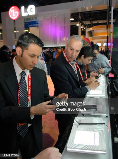 Cellular phone uses examines a Voyager LG wireless cell phone during International Consumer Electronics Show , January 7, 2008 in Las Vegas, Nevada.