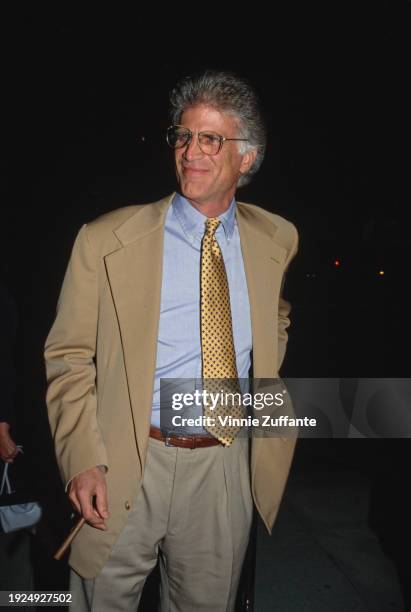 American actor Ted Danson, wearing a beige jacket over a light blue shirt with a yellow-and-blue patterned tie, attends a VIP screening of 'Indecent...
