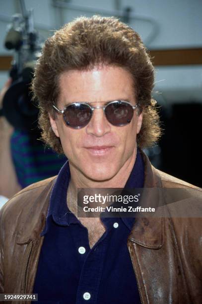 American actor Ted Danson, wearing a dark blue shirt under a brown leather jacket, with sunglasses, attends the 1994 Permanent Charities Committee of...