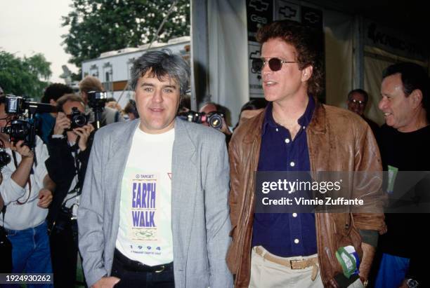 American comedian and talk show host Jay Leno, wearing a grey blazer over an 'Earth Walk' t-shirt and American actor Ted Danson, who wears a dark...