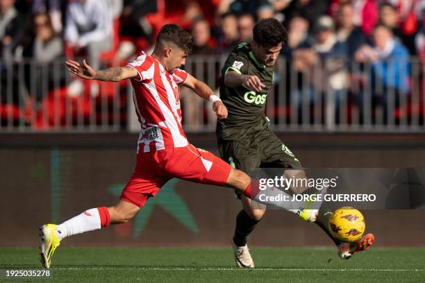 Almeria's Spanish midfielder Alex Pozo tackles Girona's Spanish defender Miguel Gutierrez during the Spanish league football match between UD Almeria...