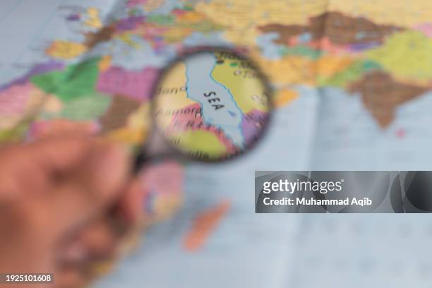 sea, magnifying glass close up with colorful world map. - karachi map stock pictures, royalty-free photos & images
