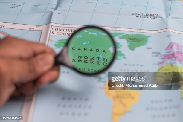 united states of america, magnifying glass close up with colorful world map. - karachi map stock pictures, royalty-free photos & images