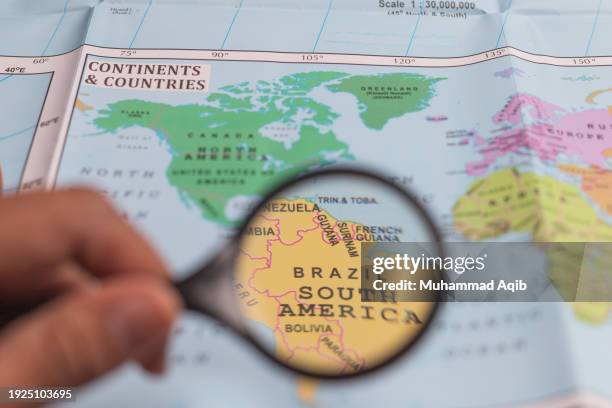 south america, magnifying glass close up with colorful world map. - karachi map stock pictures, royalty-free photos & images