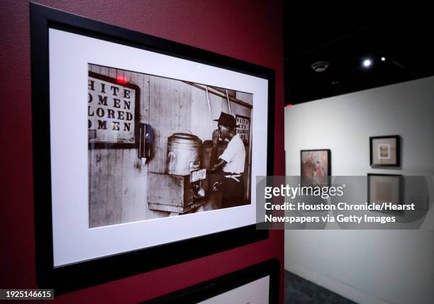 Photograph of a man drinking water from a segregated water jug is shown in The Kinsey African American Art & History Collection at Holocaust Museum...