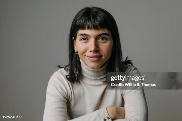 portrait of woman leaning forward on elbows, smilng - pony frisur stock-fotos und bilder