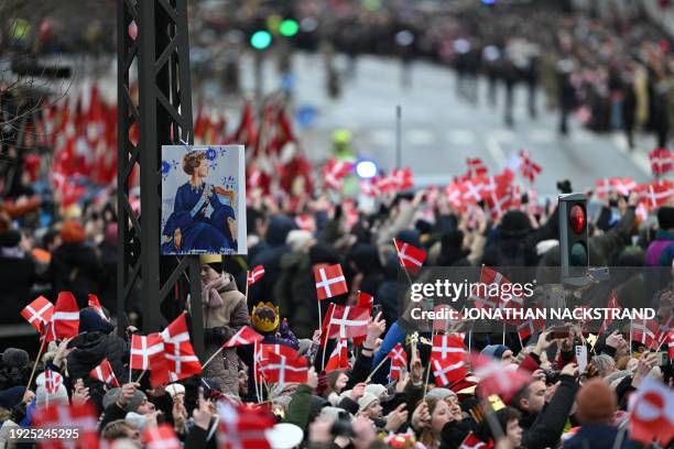 People wave flags as they wait for the Queen, Crown Prince and Crown Princess of Denmark's rides from the Amalienborg Castle to the Christiansborg...