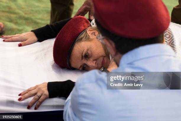 Aviva Weidenbaum lies down on the coffin during the funeral of her son Master Sgt. Daniel Weidenbaum on January 14, 2024 in Ra'anana, Israel. The...