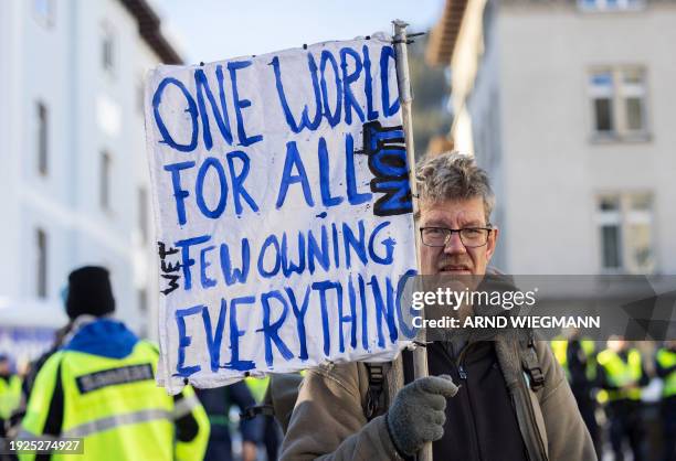 Protester holds a placard during a rally in Davos on January 14, 2024 ahead the 54th Annual Meeting of The World Economic Forum.