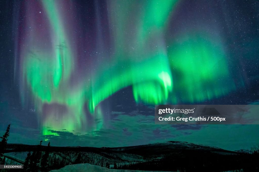 Scenic view of aurora borealis over lake at night