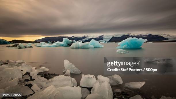 scenic view of icebergs in lake against sky during winter - stef peeters stockfoto's en -beelden