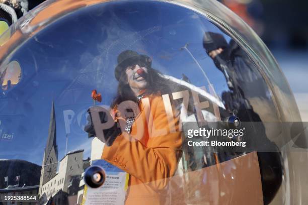Protestor dressed as a clown reflected in a police riot shield during a demonstration against the World Economic Forum ahead of its start in Davos,...