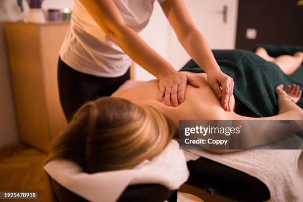 back massage, young blonde woman enjoying  massage at beauty spa salon - woman massage stock pictures, royalty-free photos & images